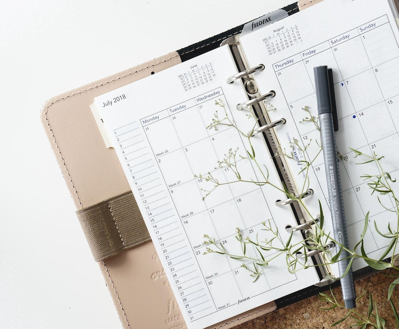 grey and black pen on calendar book